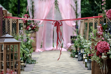 Beautiful wedding ceremony outdoors. Decorated chairs and wedding aisle with an awesome bow. Rustic style.の写真素材
