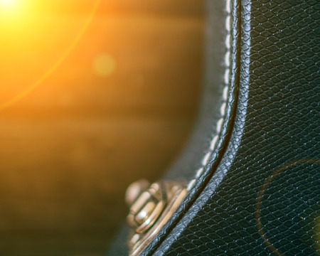 Black guitar case with wooden background. Copy space with sun light halo. Toned.の写真素材