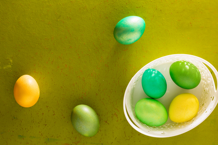 Painted Easter eggs basket on the old wooden backgroundの写真素材