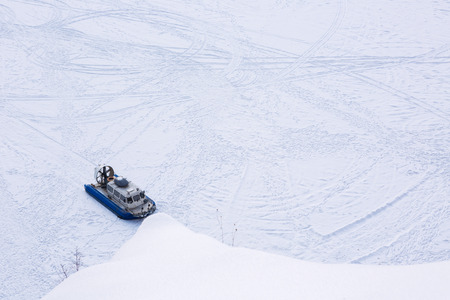Hovercraft transporter on the ice of river in winter day, The view from the topの写真素材