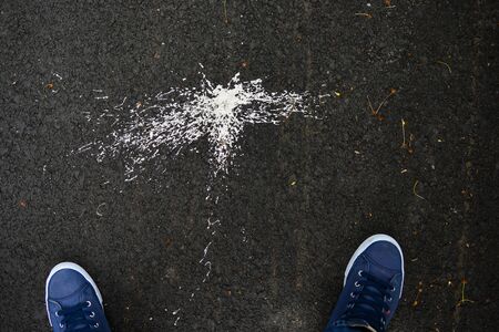 Paint sprays on asphalt. Texture. Abstract background.sneakers and paint splashes on an asphalt road.の写真素材