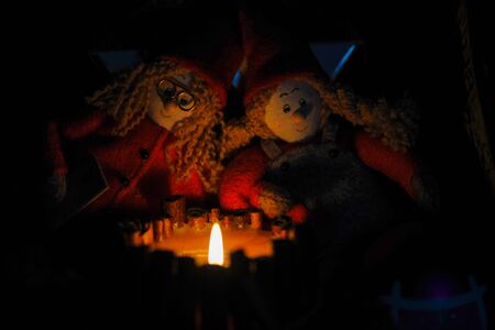 Dolls are sitting in evening by a makeshift bonfire in the form of a candle. Beautifulの写真素材
