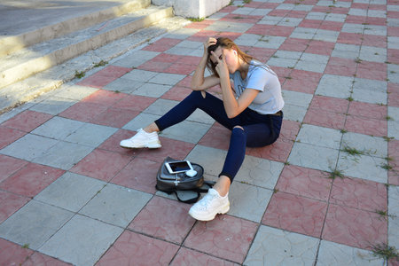 Young fresh cheerful hipster young woman sitting on the road in countryside wearing stylish summer...