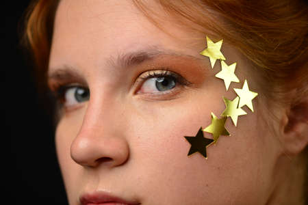 Beautiful young woman face close up portrait in studio on black.の写真素材