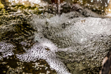 the stream of water seethes and foams. The texture of the falling water.selective focus.の写真素材