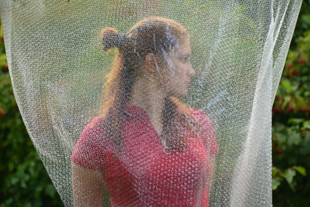 Soft blurry photo through polyethylene. model girl posing through polyethylene film. Portrait of...