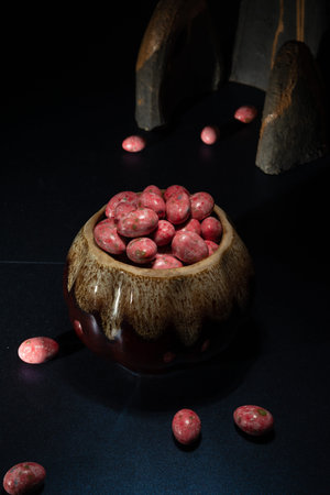 Chocolate dragees in crispy colored glaze. Dragee with almonds in a ceramic vase. Colorful candies...