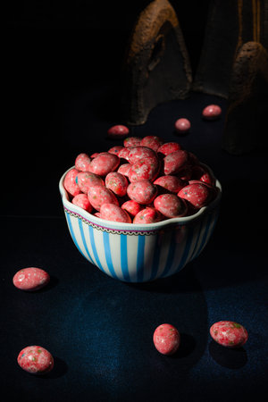 Chocolate dragees in crispy colored glaze. Dragee with almonds in a vase. Colorful candies on the...