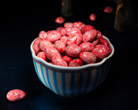 Chocolate dragees in crispy colored glaze. Dragee with almonds in a vase. Colorful candies on the...