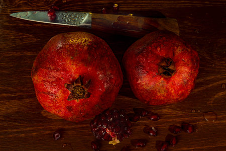 red ripe wet pomegranate on a wooden table.の写真素材