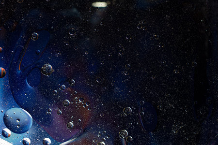 Photo of oil on a water surface with bubbles. Abstract colorful background. Macro close-up, not...