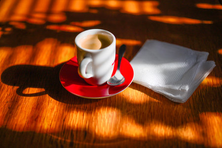 A cup of espresso on a wooden table in sunny spring morningの写真素材