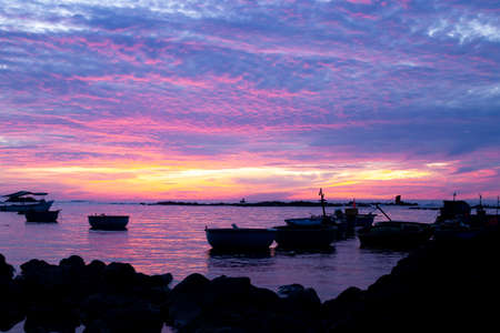 Silhouettes of fisherman's basket boats at the beach rapids, with brilliant sunrise.の写真素材
