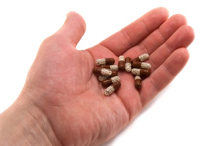 pills in hand against a white backgroundの写真素材