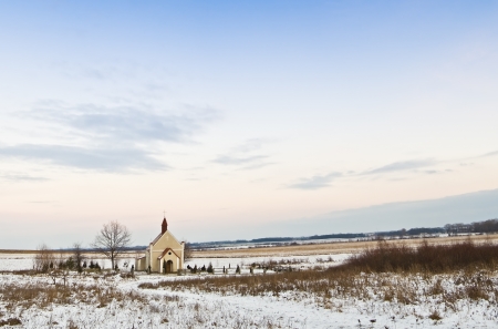 chapel in a field under blue skyの写真素材