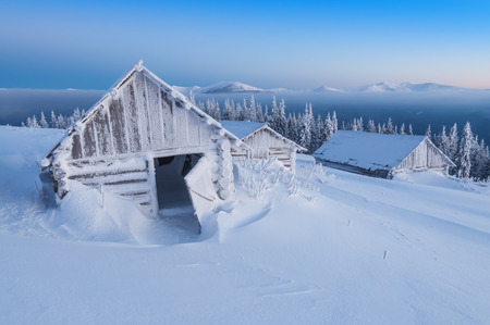 snow-covered hut (cabins) in high mountains at sunriseの写真素材