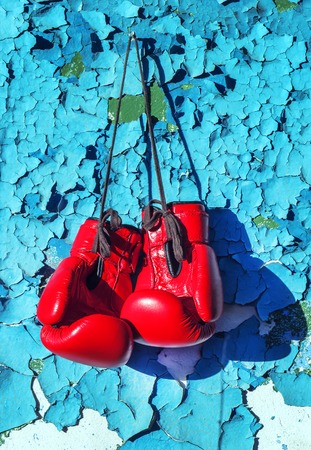 pair of boxing gloves hanging on the cracked wallの写真素材