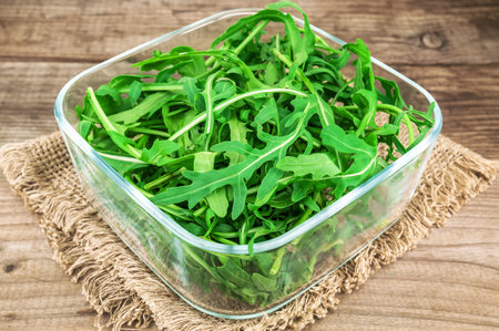 fresh and lush green arugula in glass bowl