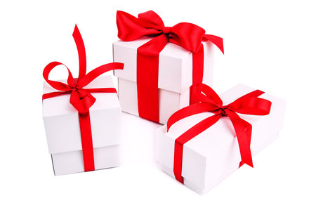 three white gift boxes with red ribbon on white background