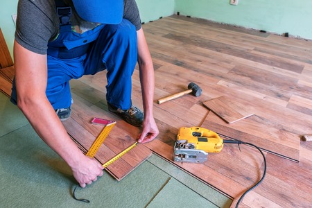 professional master in blue overalls make new laminated floorの写真素材