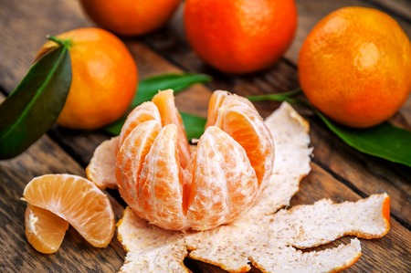 ripe and juicy mandarines (tangerine) and green leavesの写真素材