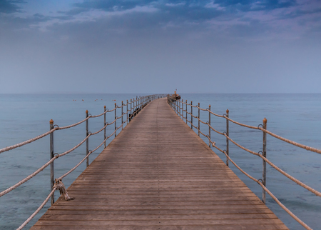 old wooden pier at sea in the evening. Cloudy skyの写真素材