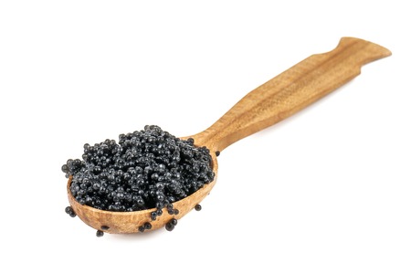 delicious black caviar in wooden spoon isolated on whiteの写真素材