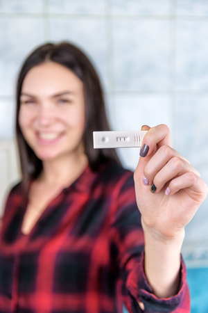 happy girl with positive pregnancy testの写真素材