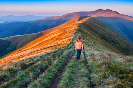 a man walking in the mountain on sunrise. beautiful landscapeの写真素材