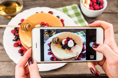 girl hand makes photo of pancakesの写真素材