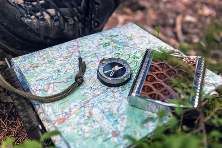 tourist compass and flask on the mapの写真素材