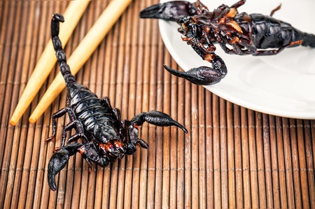 black delicious fried scorpions and chopsticksの写真素材