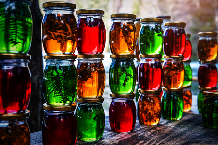 Multicolored honey in a jar on the counter. Colored jars with sweet honey or jam - green, yellow and red.の写真素材