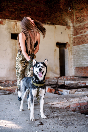 military sexy girl with dog (husky) in abandoned buildingの写真素材
