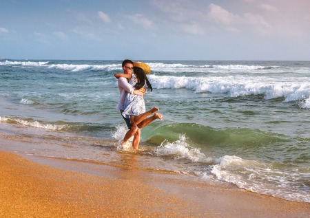 Happy honeymoon vacation at Paradise. Couple relax on the yellow sand of beach. Happy sea lifestyle. Young family, man and woman rest on the beach of ocean. Couple in love travel to island. Love travel. Sri Lankaの写真素材