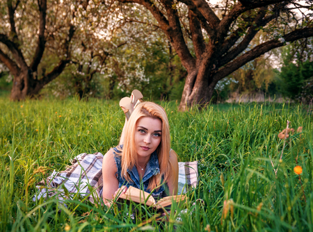 beautiful blond girl with book in the parkの写真素材