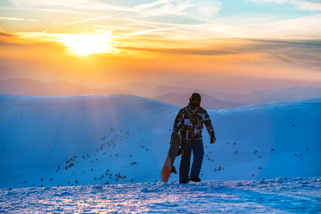 snowboarder with snowboard on beautiful sunset in the hight mountainsの写真素材