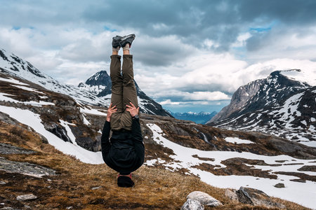 a man stands on his head in Norwegian mountains