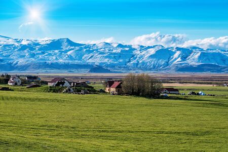 Icelandic farm and huge glacier. Beautiful sunny landscapeの写真素材