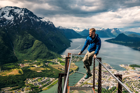 young man is sitting on rampestreken in Norway. Andalsnes