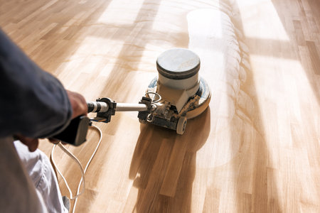 a professional master cleans the floor (parquet) with a polishing machineの写真素材