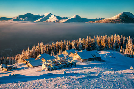 abandoned cabins in winter frosty mountains on sunriseの写真素材
