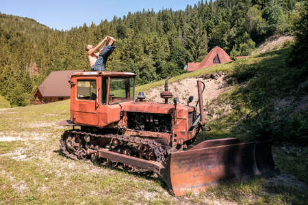 man practicing ashtanga yoga on old tractor (bulldozer)の写真素材
