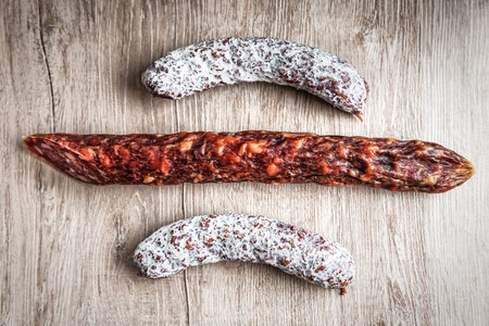 delicious dried sausages on wooden background