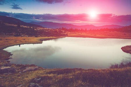 View of the mountain lake. Fantastic evening glowing by sunlight.の写真素材