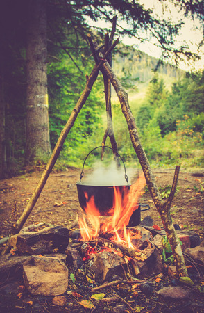 Cooking in field conditions, boiling pot at the campfire on picnic.の写真素材