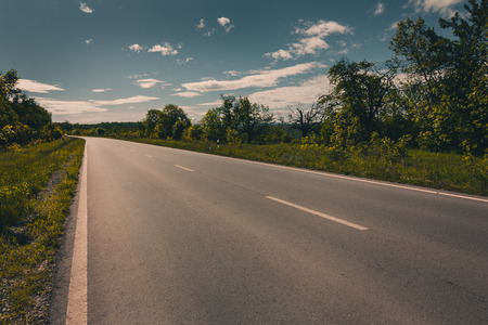 View of asphalt road, blue sky and sun. Filtered imageの写真素材
