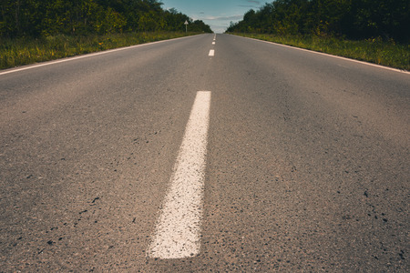 View of asphalt road, blue sky and sun. Filtered imageの写真素材