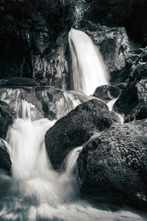 View of the stony rapids in the mountain river. Fast jet of water at slow shutter speeds give a beautiful magic effect. Black and white photo.の写真素材