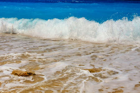 Summer seascape beautiful waves, blue sea water in sunny day. View of beautiful bright sea with waves splashing and beach sand.の写真素材